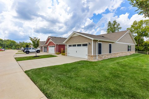 A house with a red garage door and a white car parked in front.