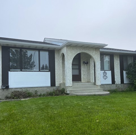 A house with a white garage door and a brown door.