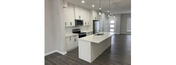 A modern kitchen with white cabinets and a large island.