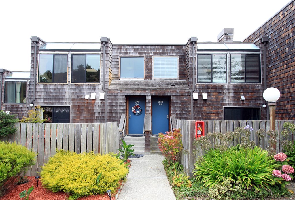 a home with a blue door and a wooden fence in front of it
