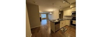 A kitchen with wooden floors and stainless steel appliances.