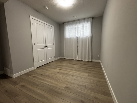 A room with a white door and a window with curtains.