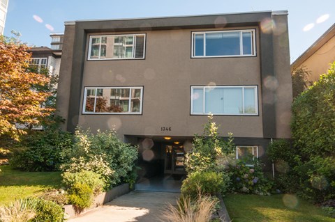 the front of a building with a sidewalk and a yard