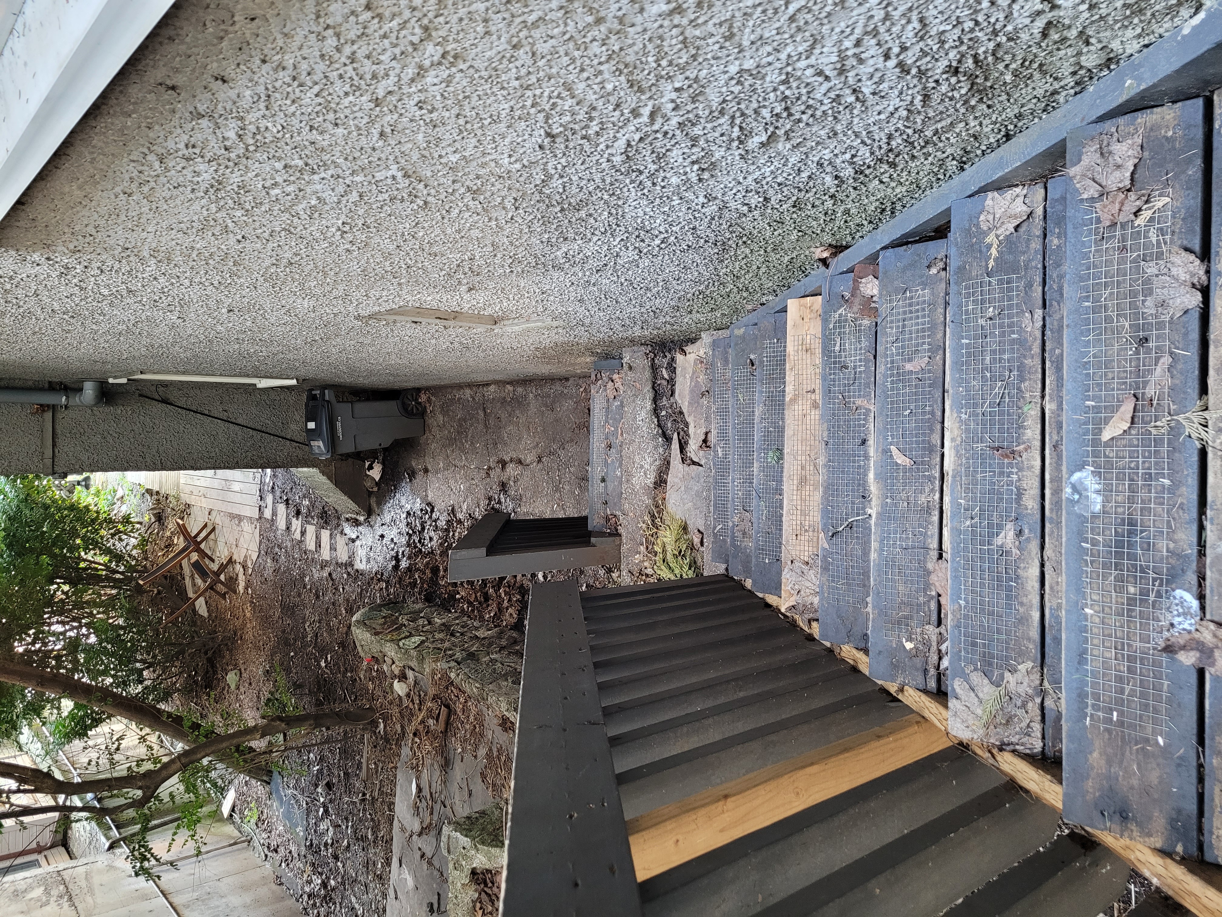A metal staircase with a metal railing and wooden steps.