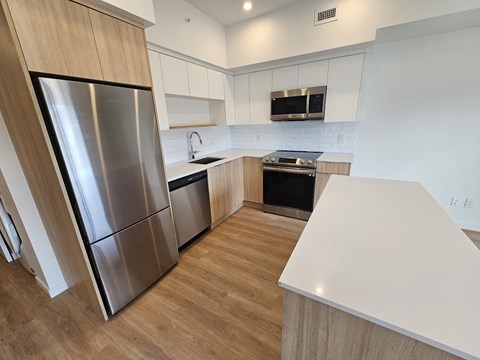 a renovated kitchen with stainless steel appliances and a white table