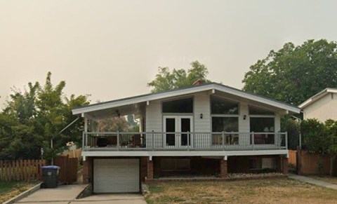 A two-story house with a balcony and a garage.