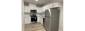 A kitchen with a stainless steel refrigerator, microwave, and oven.