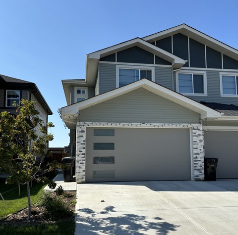 A modern house with a grey garage door.