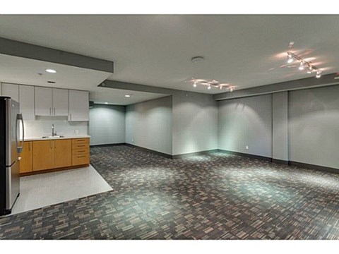 A kitchen area with a refrigerator, cabinets, and a countertop.