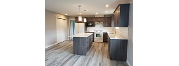 A modern kitchen with a large island and stainless steel appliances.