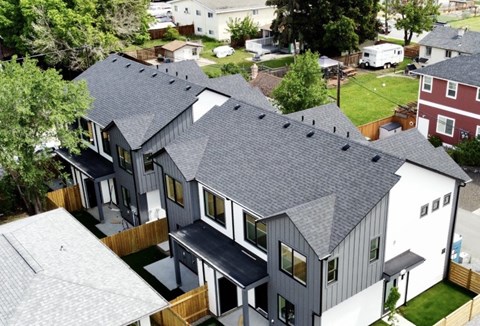 A modern house with a grey roof and white walls.
