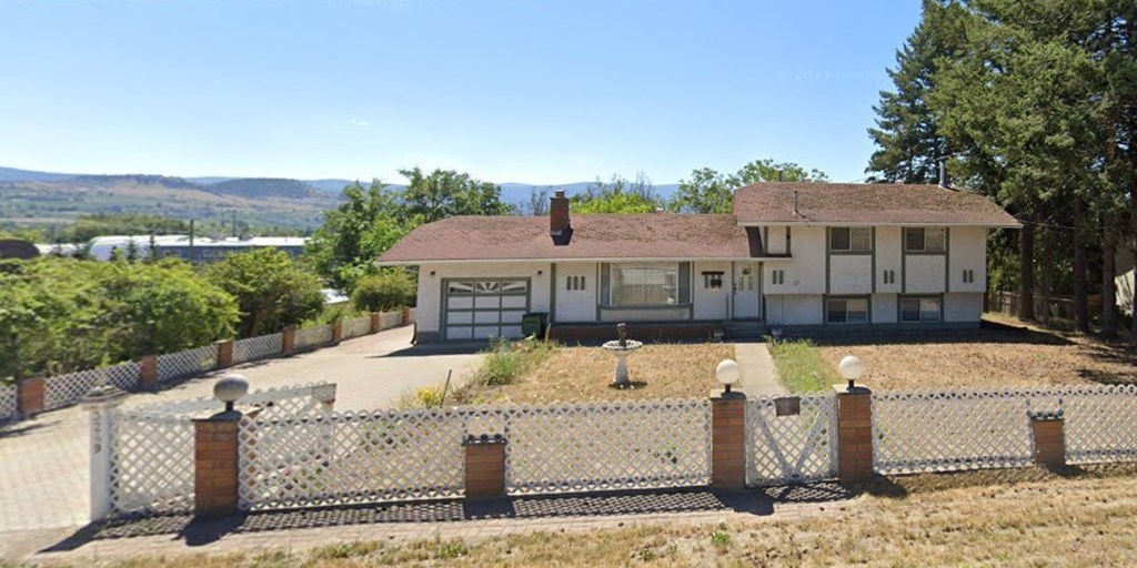 A house with a white fence in front of it.
