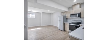 A kitchen with a refrigerator, oven, and microwave.