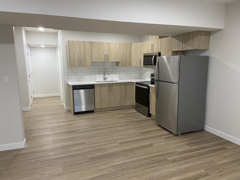 A kitchen with a refrigerator, oven, and microwave.