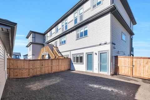 A house with a grey facade and a wooden fence.