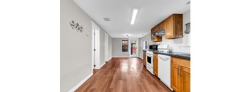 A kitchen with white appliances and wooden cabinets.