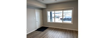 A room with a door and a window overlooking a parking lot.