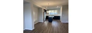 A kitchen area with a refrigerator, sink, and cabinets.