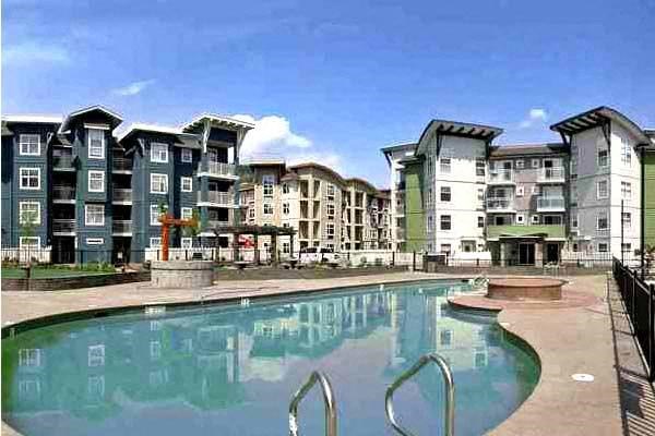 A swimming pool in front of apartment buildings.