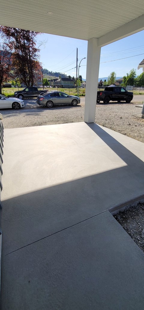 A parking lot with cars and a white building in the background.