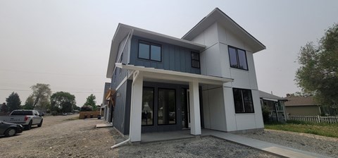 A modern house with a grey and white exterior is shown.