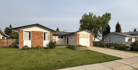 A house with a red brick chimney and a white garage door.