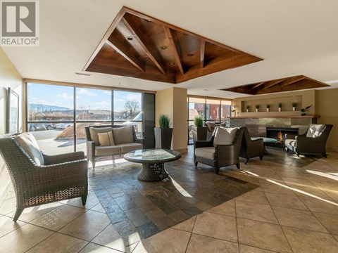 A living room with a brown tiled floor and a wooden ceiling.