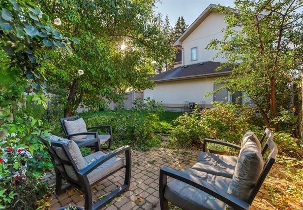 Two chairs are placed on a patio in front of a house.