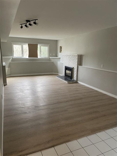 a living room with a fireplace and a wooden floor