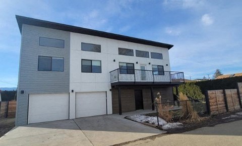 A modern two-story house with a balcony on the second floor.