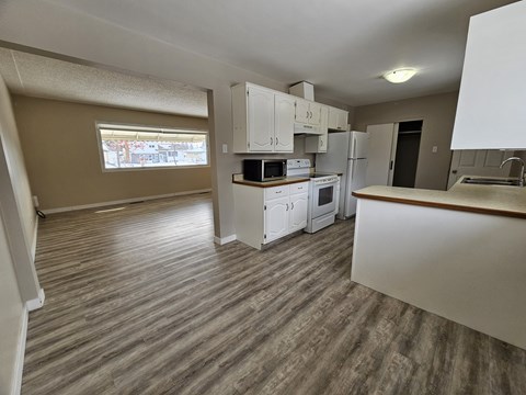 A kitchen with white cabinets and a wooden countertop.