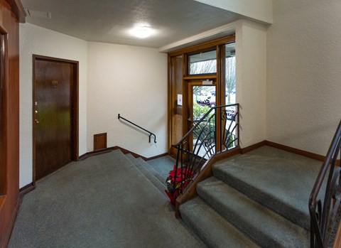 A staircase with a metal railing and a wooden door.