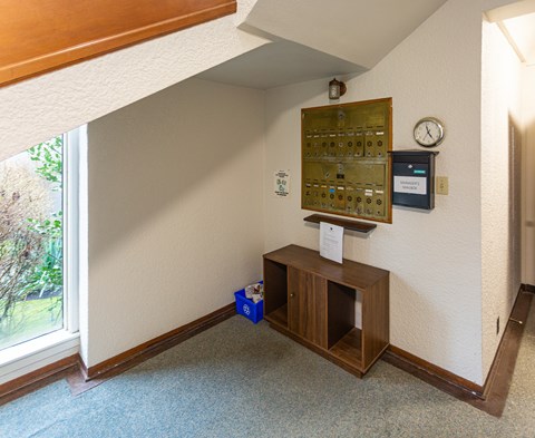 A room with a wooden bench and a control panel on the wall.