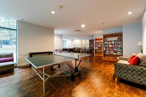 A ping pong table is in the middle of a living room.