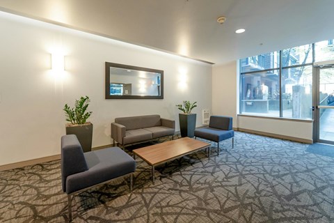 A conference room with a table, chairs and a mirror on the wall.