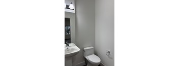 A white toilet sits next to a sink in a bathroom.