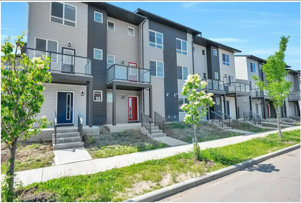 a row of town houses with stairs and a sidewalk