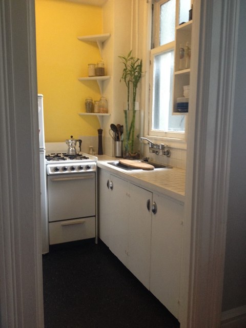 A small kitchen with a stove and sink.