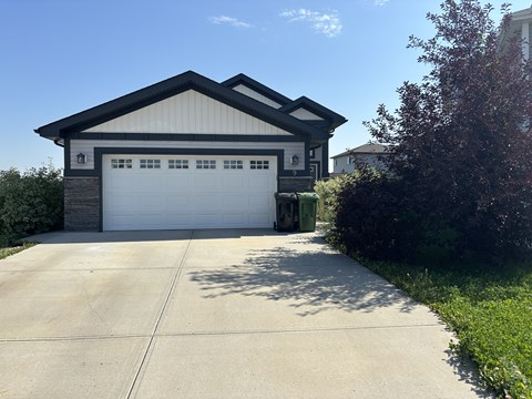 A two-car garage with a white door and a brown roof.