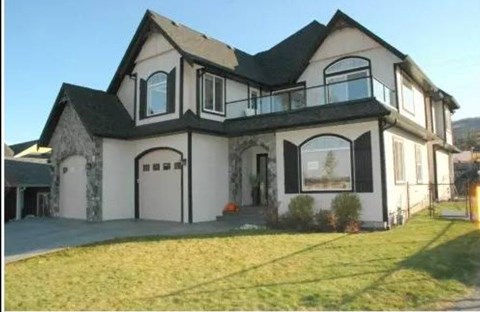 A large two-story house with a balcony on the second floor.