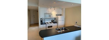 A kitchen with black countertops and white cabinets.