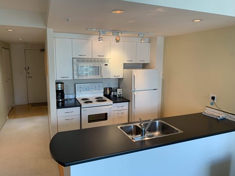 A kitchen with black countertops and white cabinets.