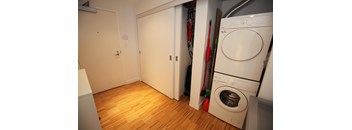 A white washing machine is in a small laundry room.
