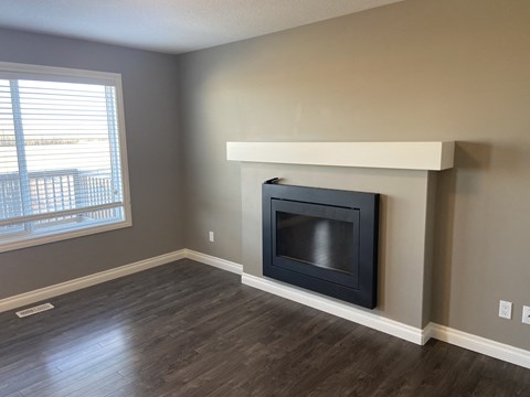 A modern living room with a fireplace and wooden flooring.