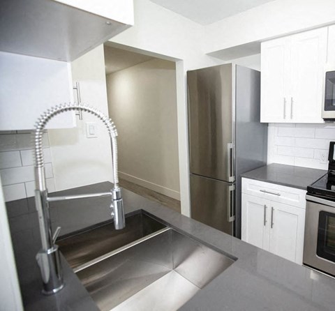 a kitchen with a sink and a stainless steel refrigerator