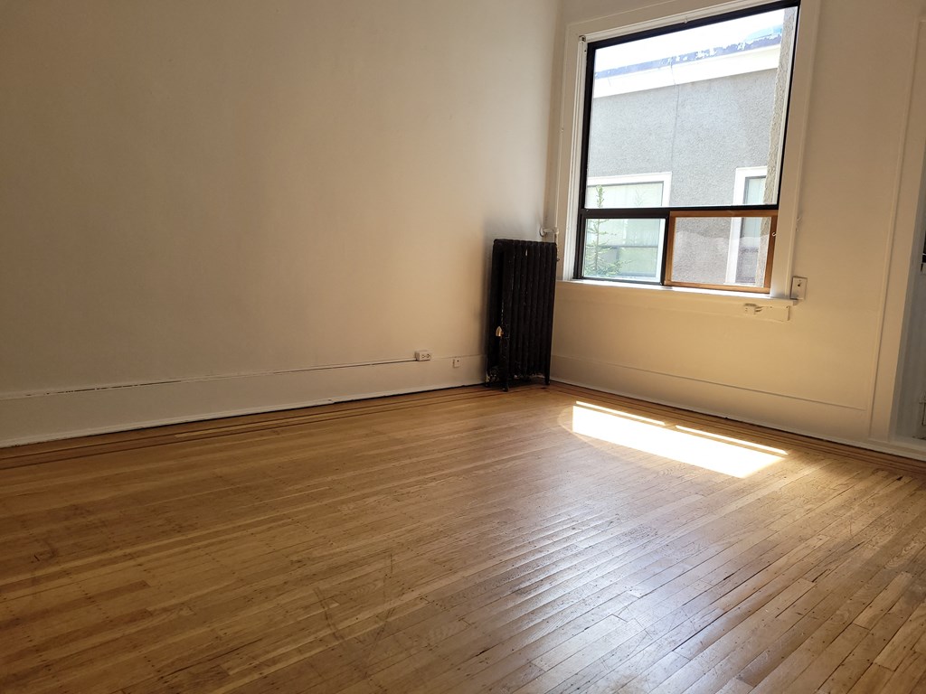 an empty room with a radiator and a window