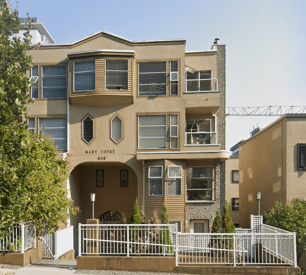 an apartment building with a fence in front of it