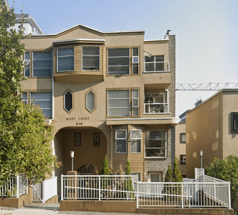 an apartment building with a fence in front of it