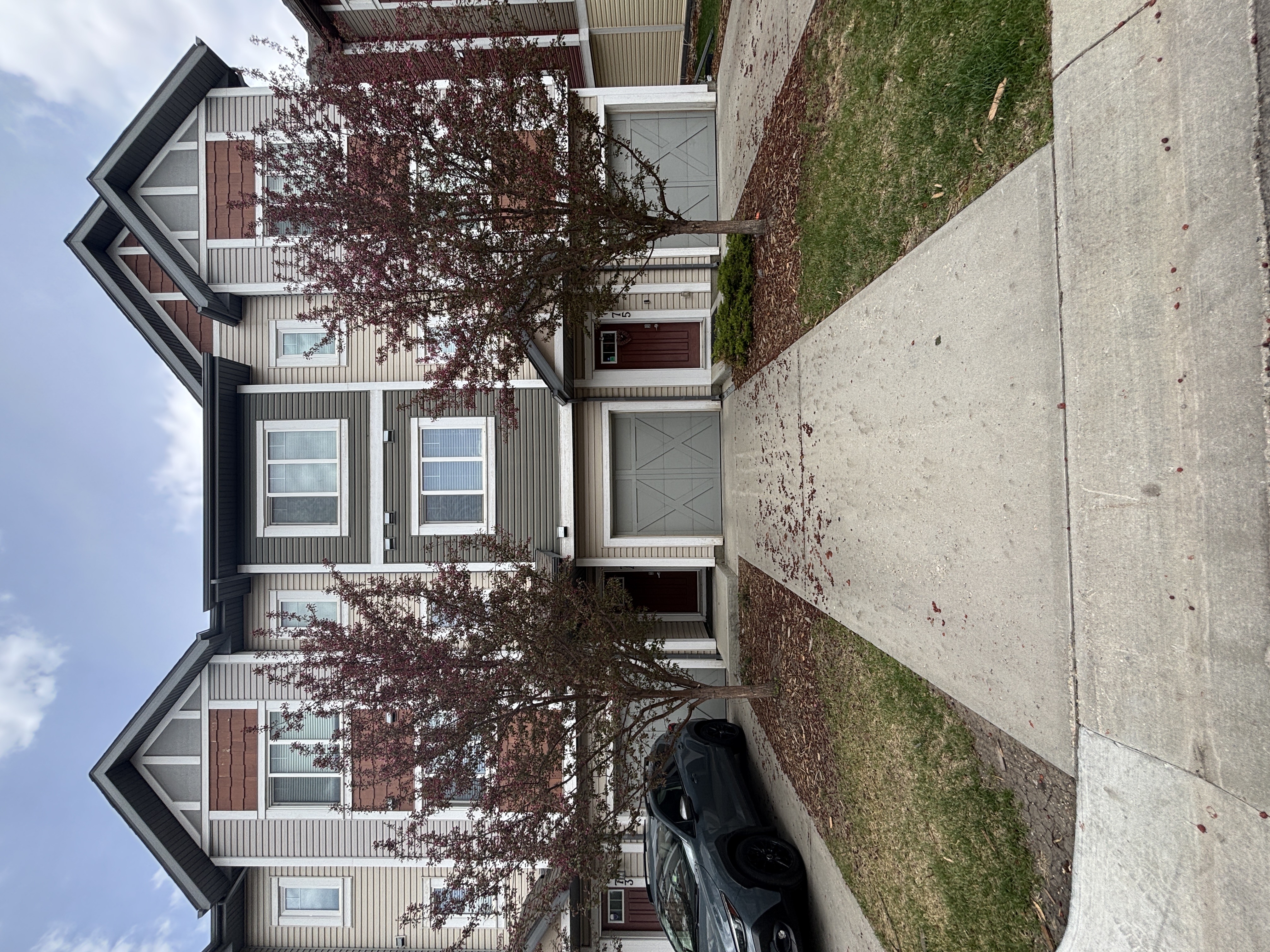 A car is parked on the side of a street in front of a house.