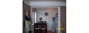 A dining room with a table and chairs and a clock on the wall.